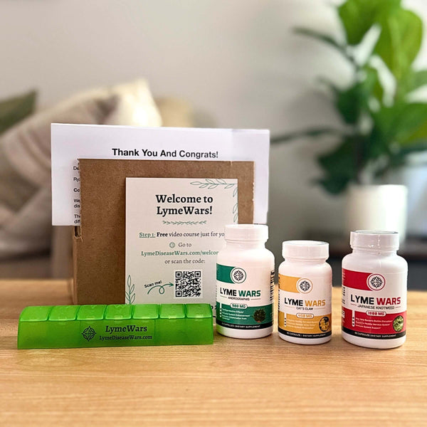 Lyme Wars herbal supplement recovery kit with Andrographis, Cat’s Claw, Japanese Knotweed, pill organizer, and welcome materials on a table