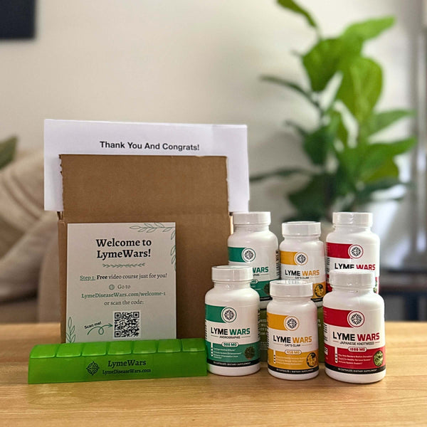 Lyme Wars dual pack recovery kit with supplements, welcome box, pill organizer, and printed welcome guide on a table