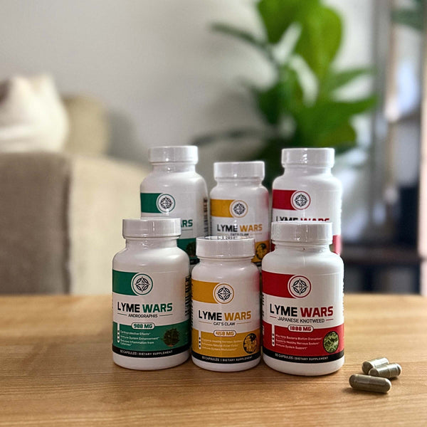 Lyme Wars dual pack herbal supplements including Andrographis, Cat’s Claw, and Japanese Knotweed, shown with capsules on a table