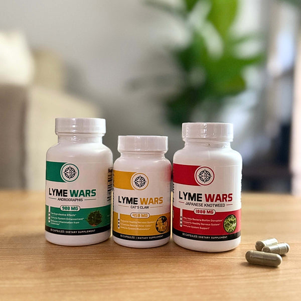 LymeWars herbal supplement bottles for Lyme disease recovery: Andrographis, Cat’s Claw, and Japanese Knotweed, with capsules on a table